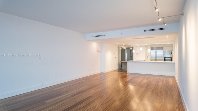 unfurnished living room featuring sink, hardwood / wood-style floors, and a barn door