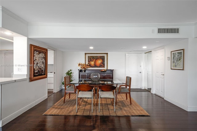 dining area with ornamental molding and dark hardwood / wood-style floors