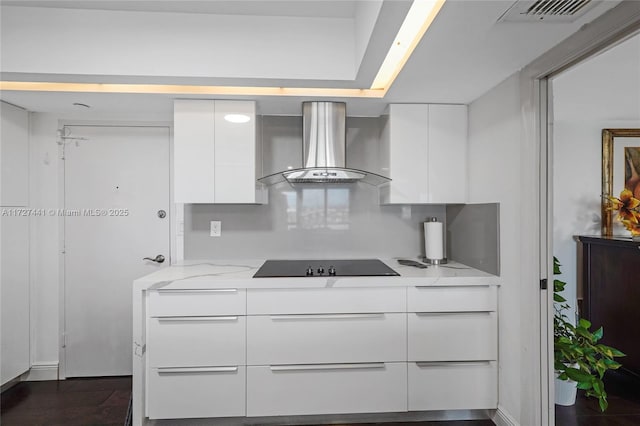 kitchen with ventilation hood, white cabinetry, black electric stovetop, light stone counters, and dark wood-type flooring