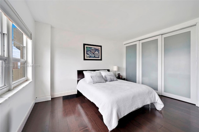 bedroom with dark hardwood / wood-style flooring and a closet