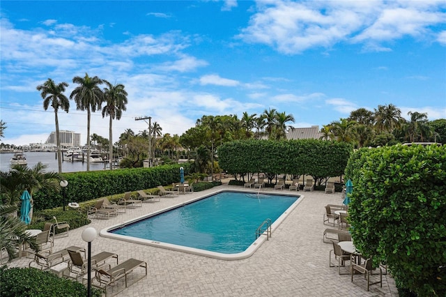 view of swimming pool featuring a patio and a water view