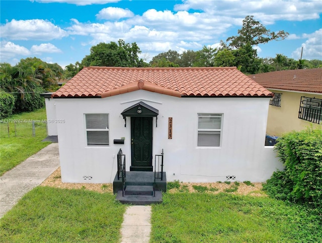 mediterranean / spanish home with a front lawn