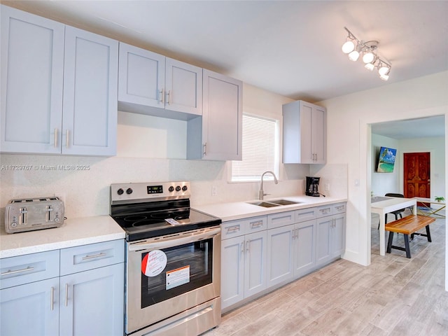 kitchen featuring sink, light hardwood / wood-style floors, tasteful backsplash, and stainless steel electric stove