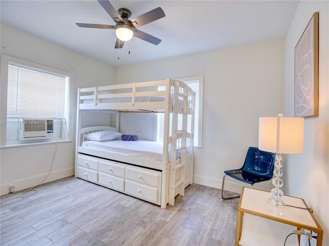 bedroom with ceiling fan, cooling unit, and light hardwood / wood-style flooring