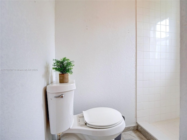 bathroom with toilet and tiled shower