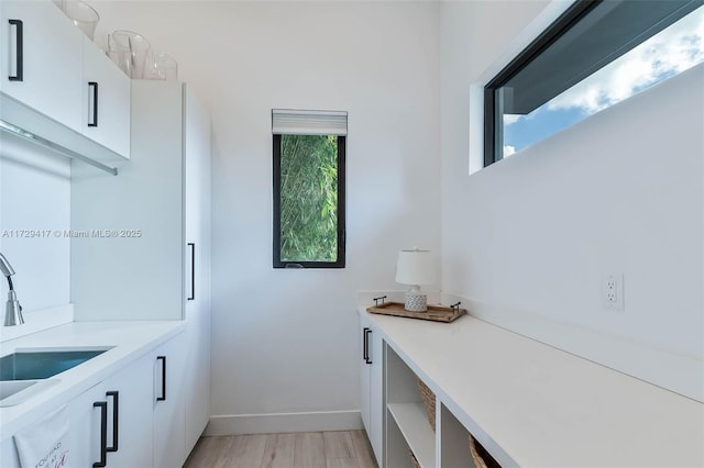 laundry room with sink and light hardwood / wood-style flooring