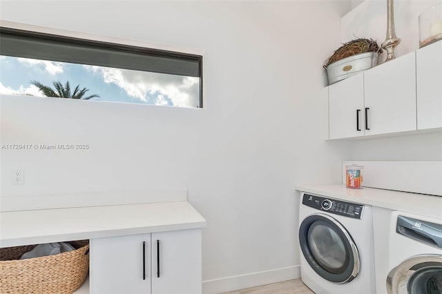 laundry area with independent washer and dryer, cabinets, and light hardwood / wood-style floors