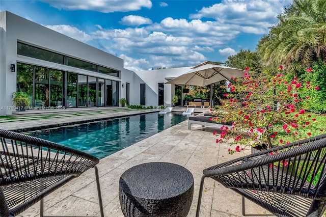 view of pool featuring a patio and a hot tub