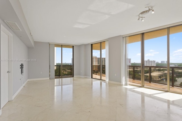 empty room featuring a wall of windows and a wealth of natural light