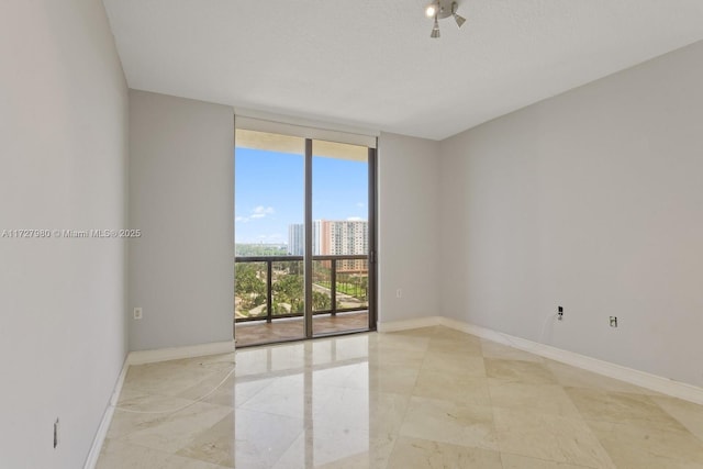 spare room featuring a textured ceiling and a wall of windows