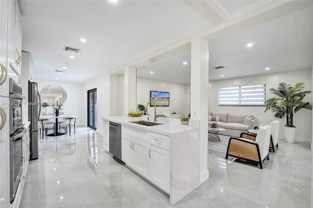 kitchen featuring white cabinetry, appliances with stainless steel finishes, sink, and light stone counters