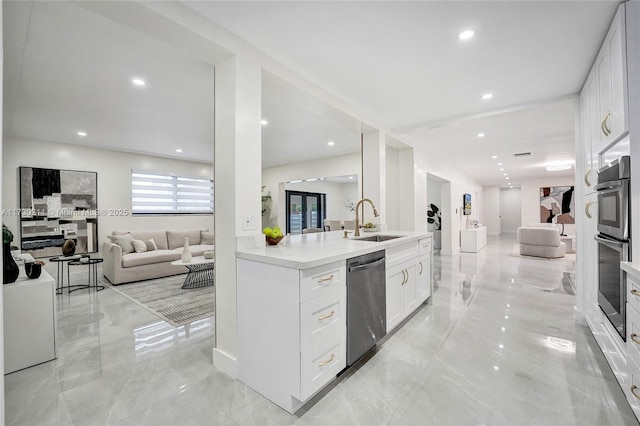 kitchen featuring white cabinetry, appliances with stainless steel finishes, kitchen peninsula, and sink