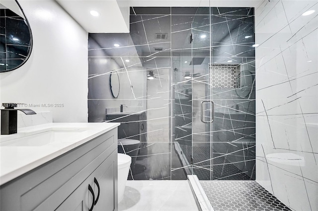 bathroom featuring vanity, toilet, and a shower with door