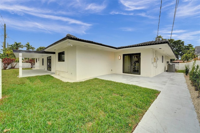 rear view of house with a yard, a patio, and central air condition unit