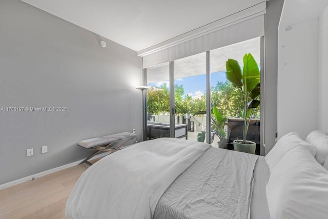 bedroom featuring access to exterior and light hardwood / wood-style flooring