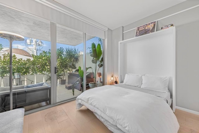 bedroom featuring hardwood / wood-style floors and access to outside