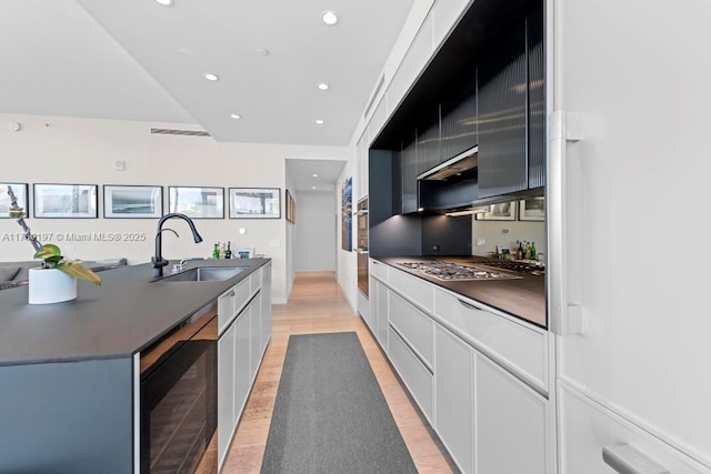 kitchen with wine cooler, sink, white cabinets, and stainless steel gas stovetop