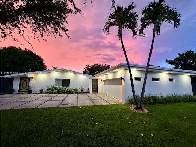 view of front of home with a garage and a yard