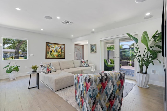 living room with french doors and light hardwood / wood-style floors