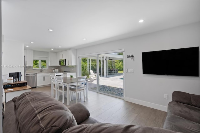 living room featuring sink and light hardwood / wood-style flooring