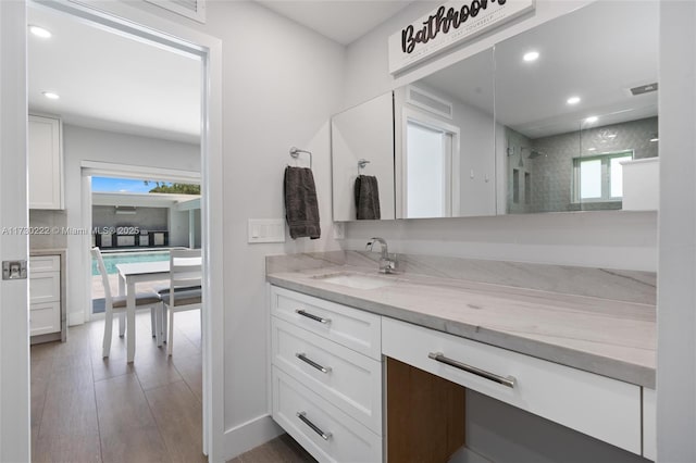 bathroom featuring vanity, wood-type flooring, a wealth of natural light, and an enclosed shower