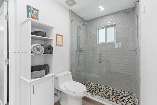 bathroom featuring an enclosed shower and toilet