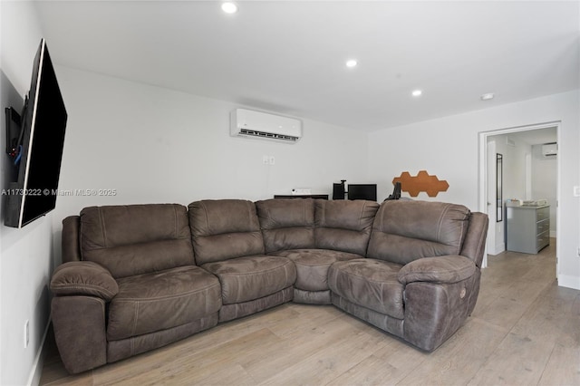 living room with an AC wall unit and light wood-type flooring