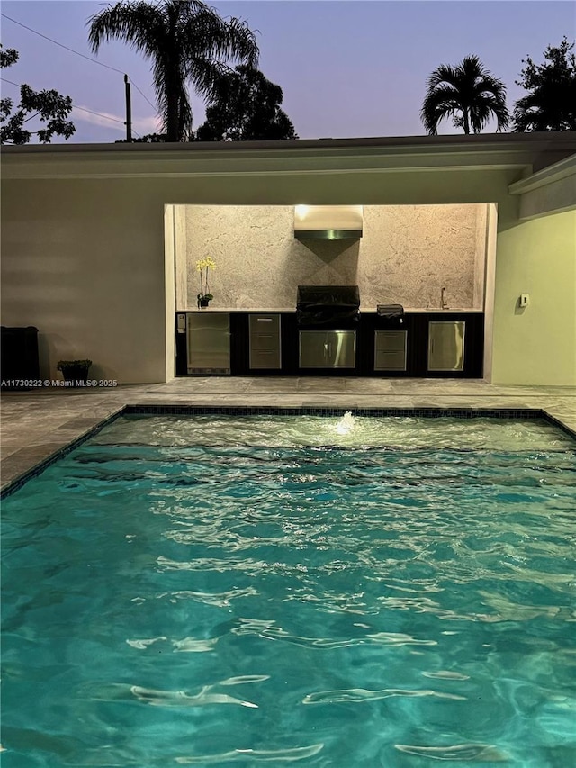 pool at dusk featuring a grill