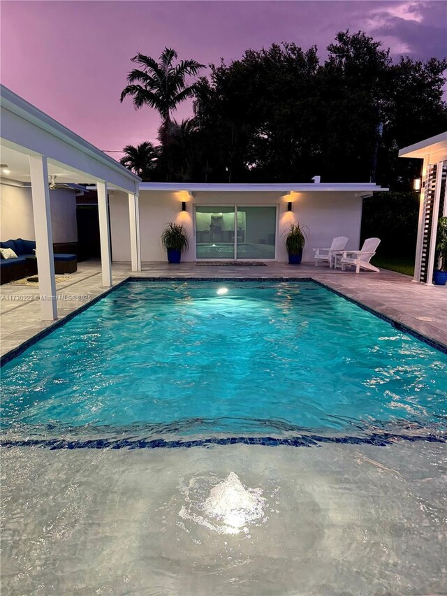 pool at dusk with a patio