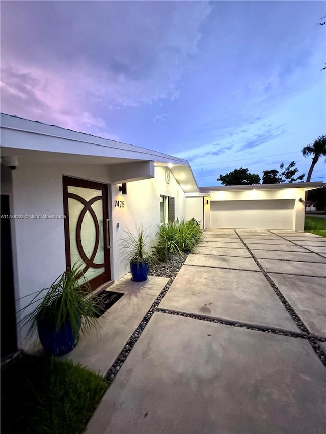 exterior entry at dusk with a garage