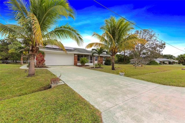 view of front of property featuring a garage, solar panels, and a front lawn