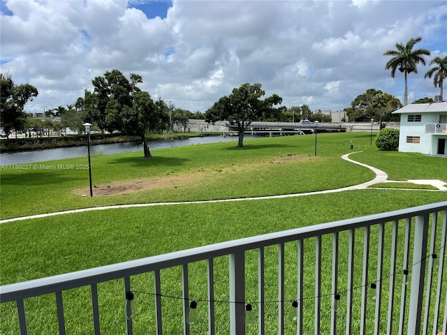 view of home's community with a water view and a lawn