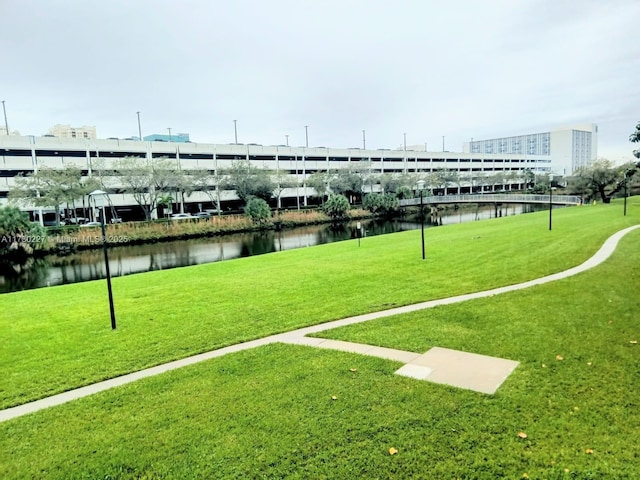 view of community with a lawn and a water view