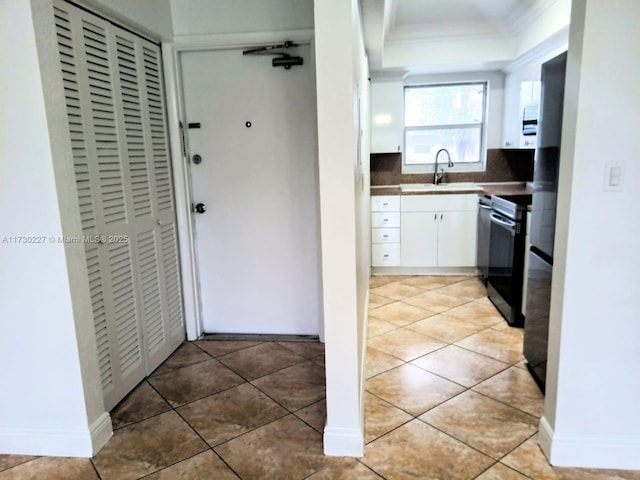 kitchen with white cabinetry, ornamental molding, tile patterned flooring, and range with electric cooktop