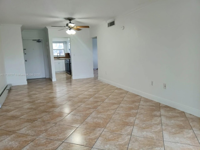 unfurnished room featuring visible vents, crown molding, baseboards, baseboard heating, and a sink