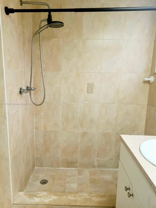 full bath featuring vanity and a tile shower