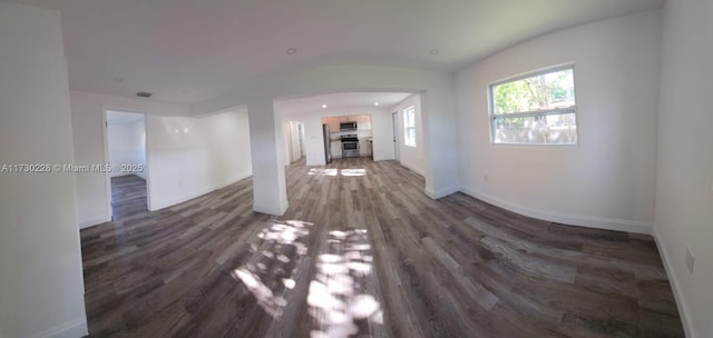 unfurnished living room featuring dark wood-type flooring