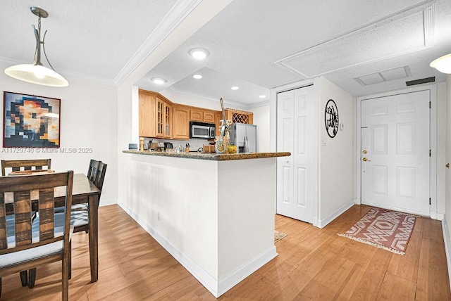 kitchen with crown molding, light wood-type flooring, decorative light fixtures, kitchen peninsula, and stainless steel appliances