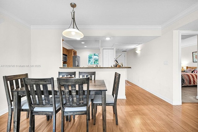 dining area featuring light hardwood / wood-style flooring and ornamental molding