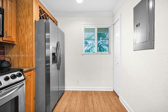 kitchen with appliances with stainless steel finishes, electric panel, dark stone counters, ornamental molding, and light hardwood / wood-style floors