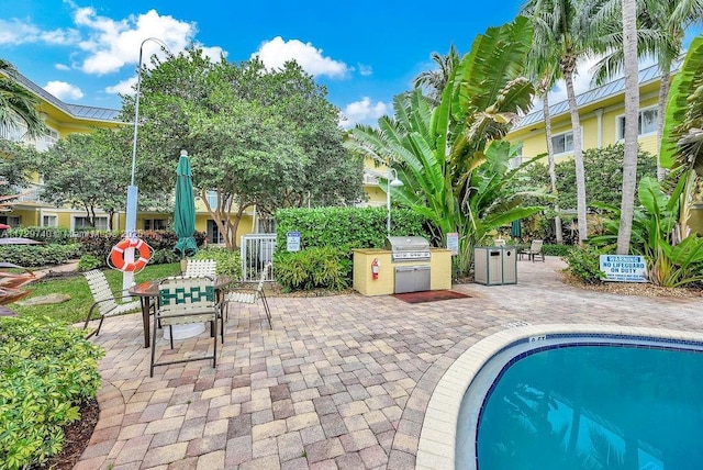 view of swimming pool featuring a patio area, grilling area, and area for grilling