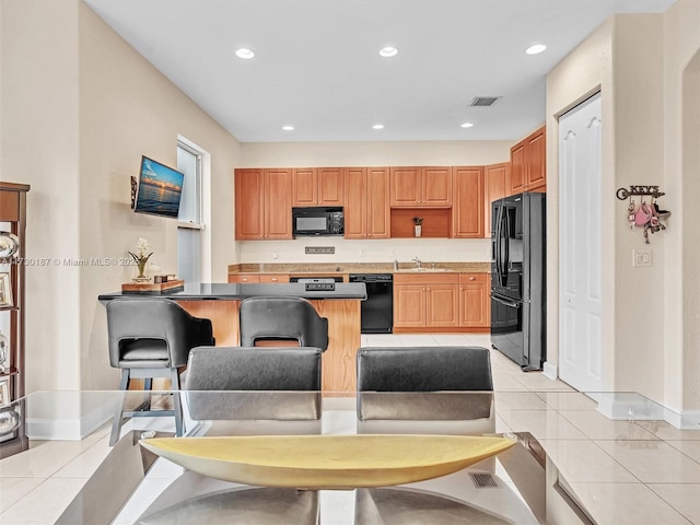 kitchen featuring light tile patterned floors, black appliances, and sink