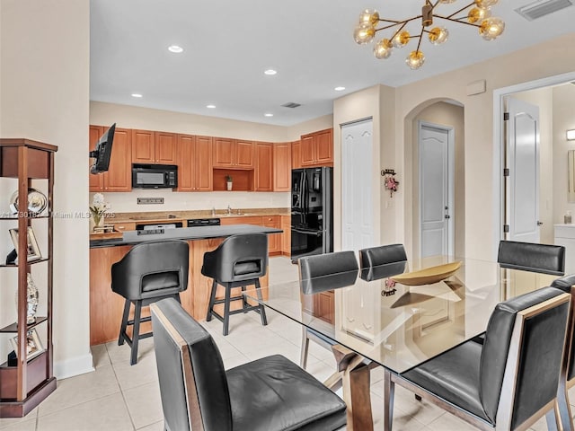 dining space with an inviting chandelier, sink, and light tile patterned floors