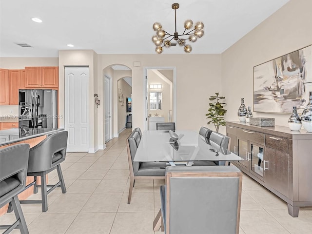 dining space with light tile patterned floors and an inviting chandelier