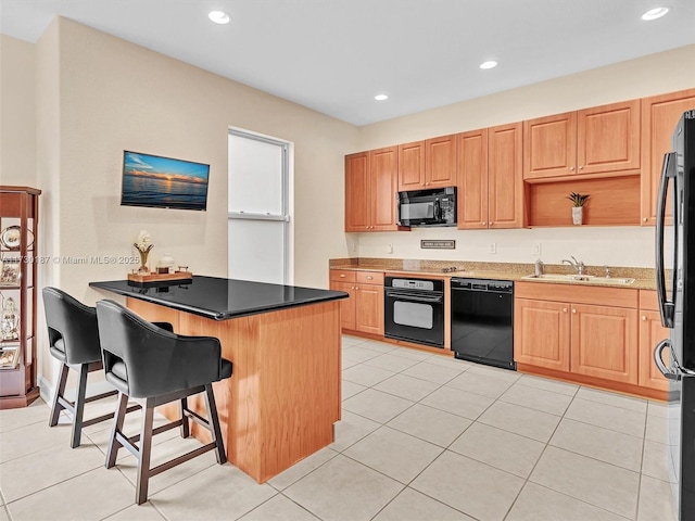 kitchen with black appliances, sink, a kitchen breakfast bar, light tile patterned floors, and kitchen peninsula