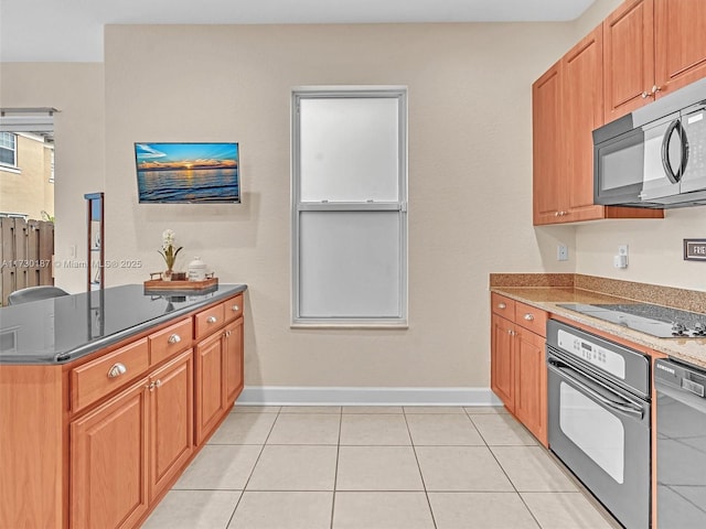 kitchen with kitchen peninsula, light tile patterned floors, and black appliances