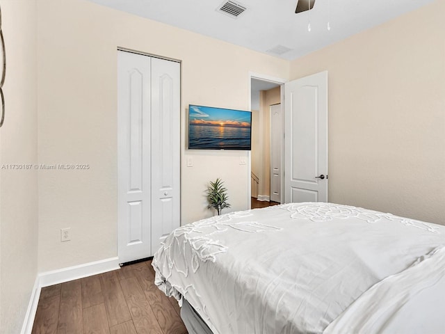 bedroom with dark hardwood / wood-style floors, ceiling fan, and a closet