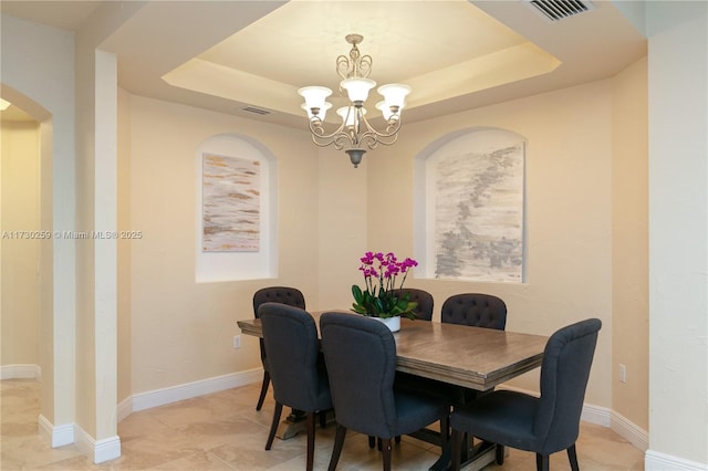 dining room with light tile patterned flooring, a chandelier, and a raised ceiling