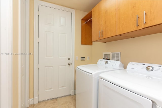 washroom featuring cabinets and washer and clothes dryer