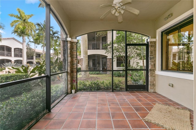 unfurnished sunroom featuring ceiling fan